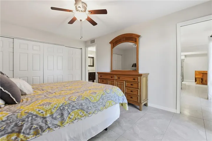 Bedroom with a closet, a ceiling fan, and ensuite bath