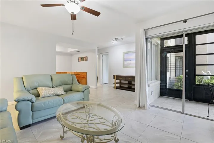 Living area featuring a ceiling fan and light tile patterned flooring
