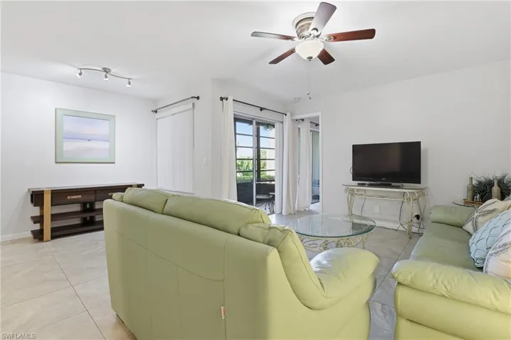 Living room featuring light tile patterned floors and a ceiling fan