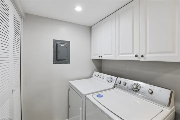 Laundry room with electric panel, cabinet space, separate washer and dryer, and recessed lighting
