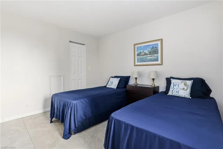 Tiled bedroom featuring baseboards and a closet