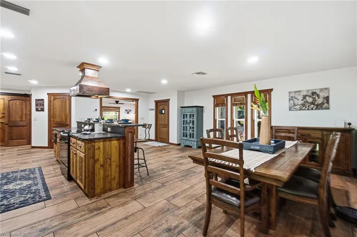 Open kitchen and dining area with wood look tile flooring throughout