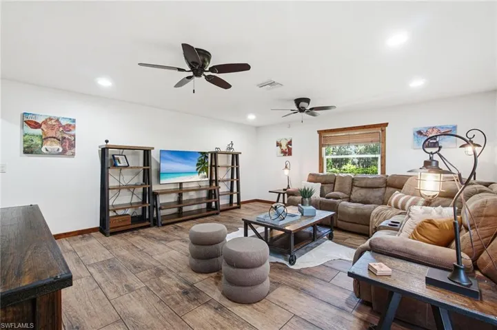 Main living area with multiple windows and ceiling fans