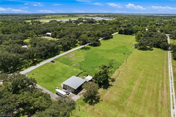 Elevated view showing the residence, surrounding grounds and neighboring landscaping