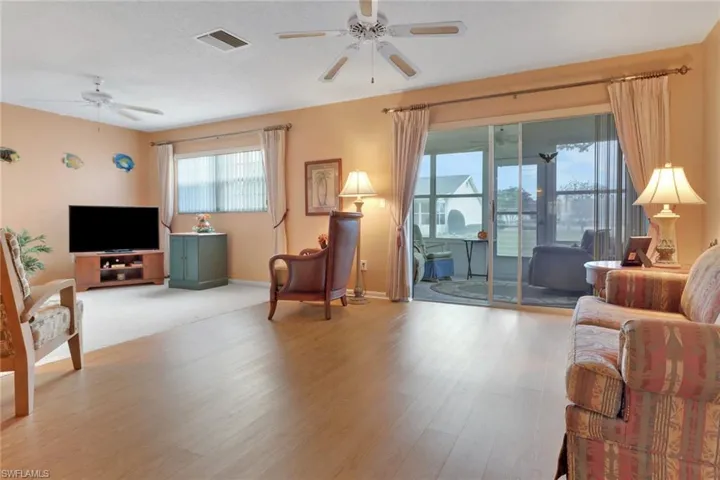 Bright & spacious living room with sliding door leading to glass-enclosed Florida Room