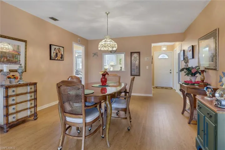 Dining room with unique light fixture & light wood-type flooring