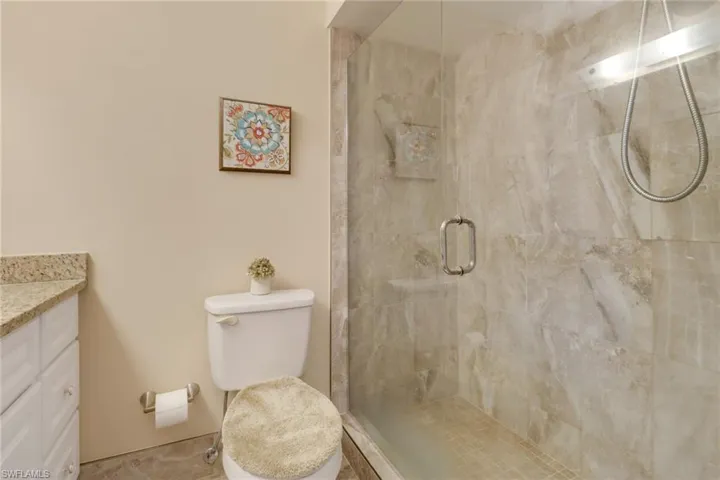 Primary bathroom with upgraded, frameless, glass-enclosed tiled shower