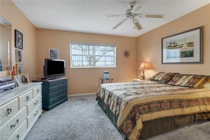 Carpeted primary bedroom is painted a soft color to promote relaxation