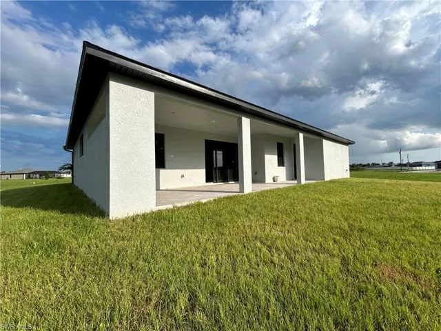 Back of property with a patio area and a lawn