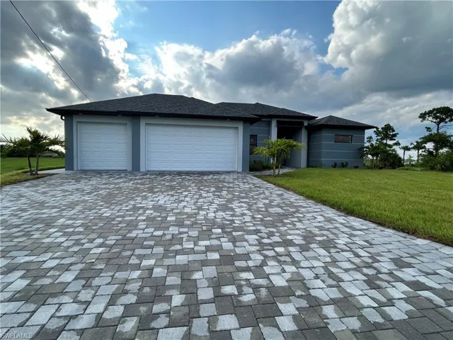 View of front facade with a garage and a front lawn