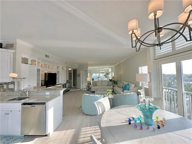 Dining room featuring suspended lighting, light wood-type flooring, and crown molding
