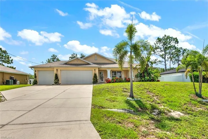 View of front of house featuring a 3 car garage, a front yard, and central AC unit