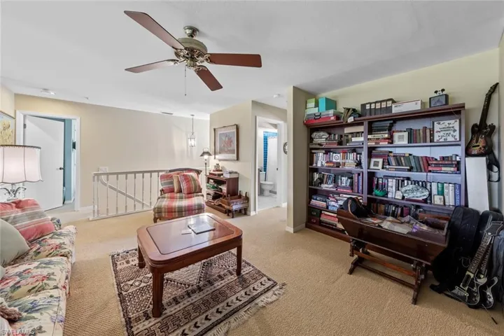 Carpeted living room with ceiling fan