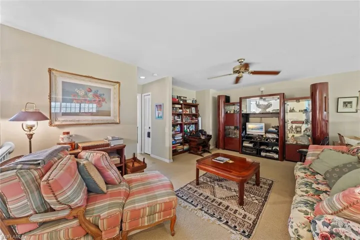 Carpeted living room with ceiling fan
