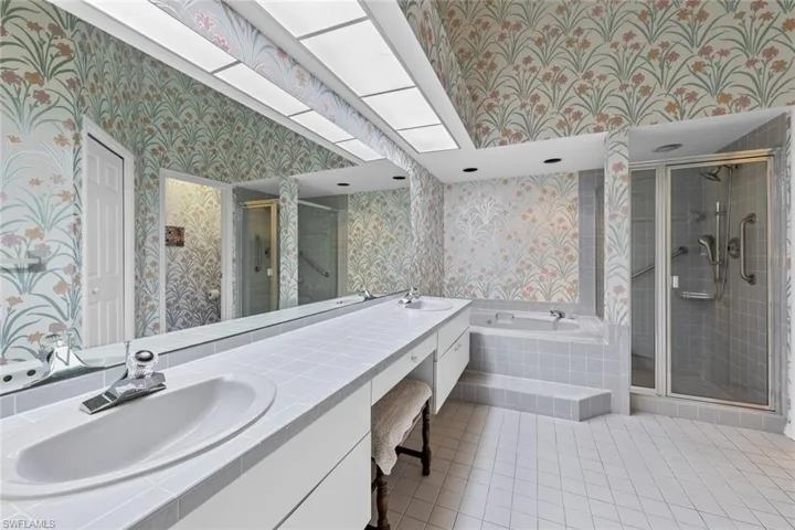 Bathroom with vanity, shower with separate bathtub, and tile patterned floors