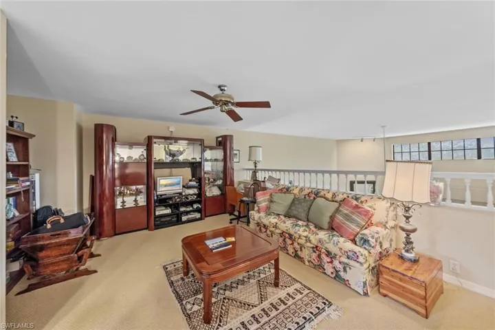 Carpeted living room featuring ceiling fan