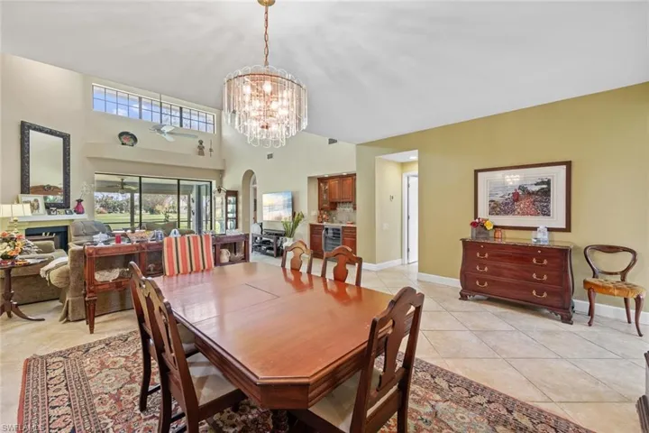 Dining space with wine cooler, a chandelier, and light tile patterned flooring
