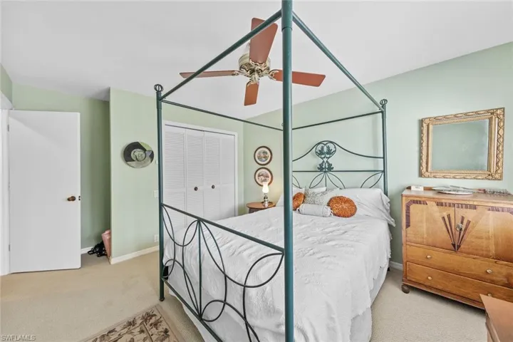 Bedroom featuring a closet, light colored carpet, and ceiling fan