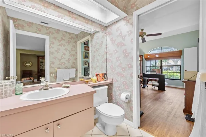 Bathroom featuring vanity, toilet, ceiling fan, and hardwood / wood-style floors
