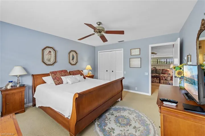 Carpeted bedroom with a closet and ceiling fan