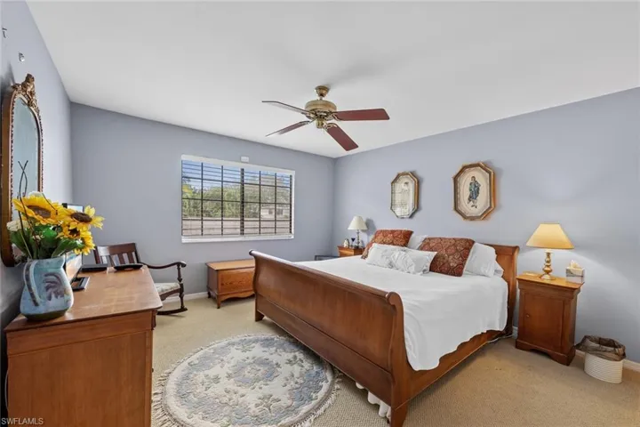 Carpeted bedroom featuring ceiling fan