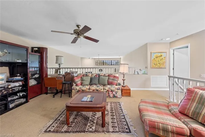 Carpeted living room with ceiling fan