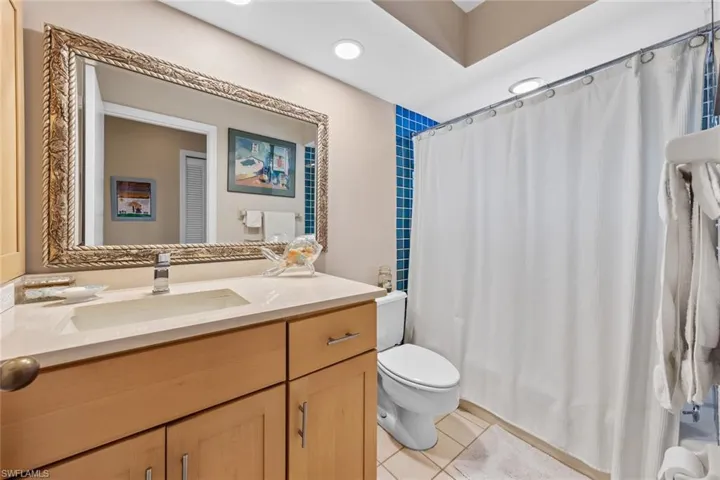 Bathroom with vanity, curtained shower, toilet, and tile patterned floors