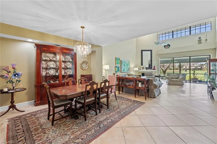 Tiled dining area featuring ceiling fan with notable chandelier