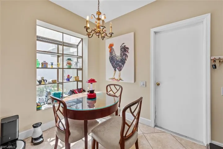 Tiled dining room with a chandelier