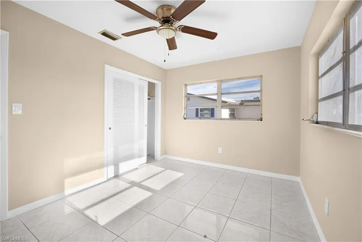 Unfurnished bedroom with a ceiling fan, a closet, and light tile patterned flooring
