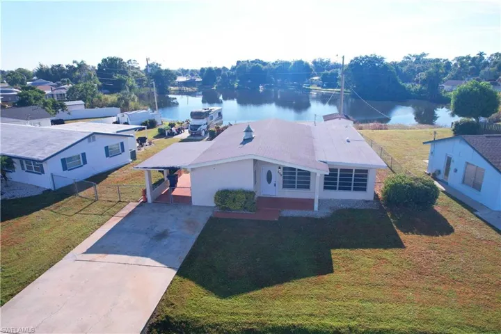 Aerial view of property and surrounding area featuring a nearby body of water