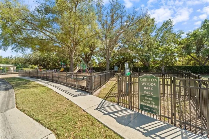 View of home's community with fence, playground community, and a lawn