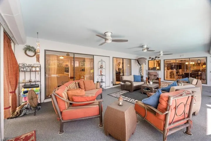 Carpeted living room featuring ceiling fan