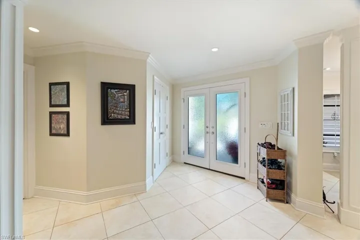 Entrance foyer with light tile patterned floors, baseboards, recessed lighting, ornamental molding, and french doors