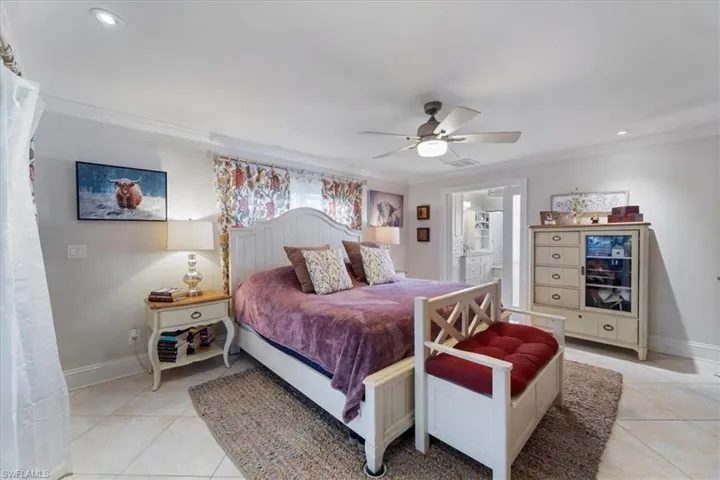 Bedroom featuring light tile patterned flooring, visible vents, baseboards, and ornamental molding