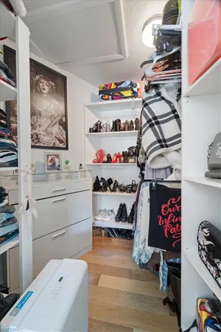 Walk in closet with light wood finished floors