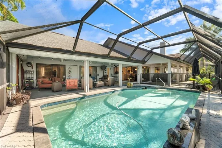Pool featuring ceiling fan, a patio, glass enclosure, and an outdoor hangout area