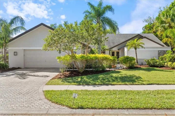 View of front facade with stucco siding, an attached garage, decorative driveway, and a front yard
