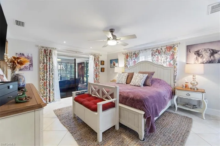 Bedroom with light tile patterned floors, visible vents, access to exterior, and crown molding