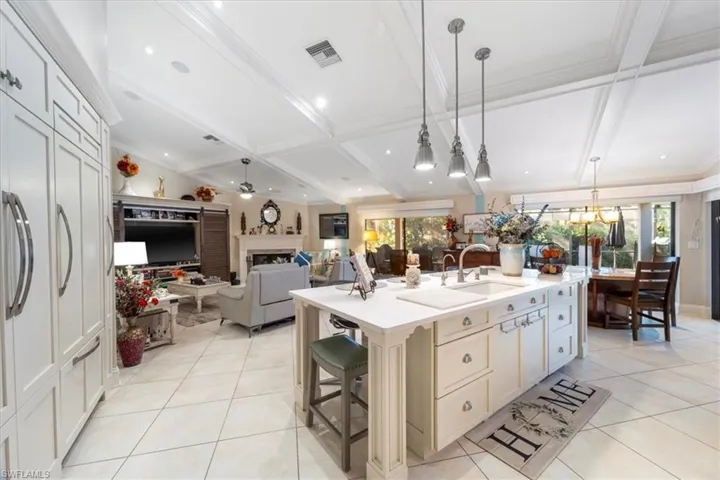 Kitchen featuring light tile patterned floors, visible vents, a fireplace, and a sink