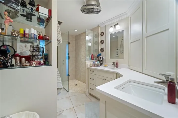 Full bathroom featuring tile patterned floors, ornamental molding, vanity, and a walk in shower