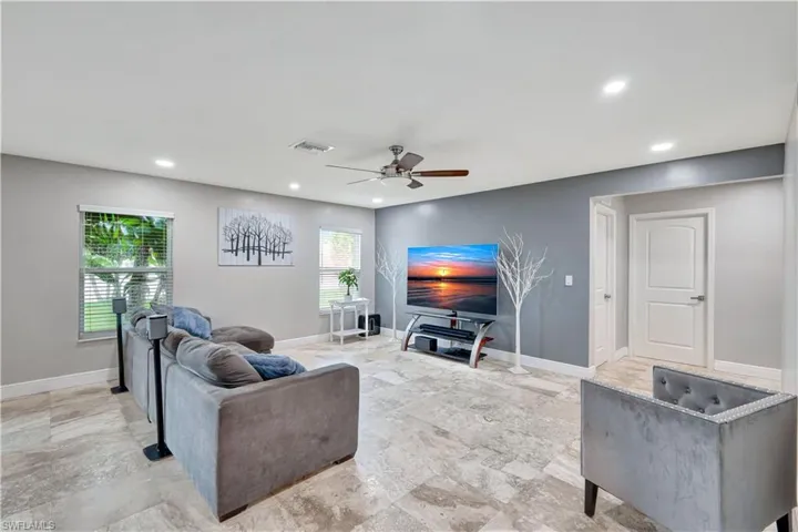 Living area with healthy amount of natural light, recessed lighting, and a ceiling fan