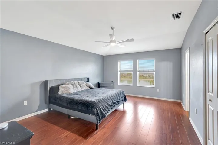 Bedroom featuring a closet, dark wood-style floors, and a ceiling fan