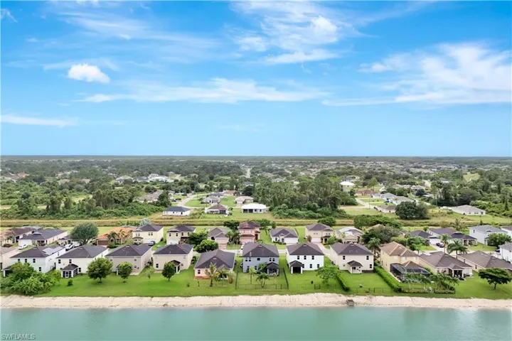 Aerial perspective of suburban area with a large body of water and a tree filled landscape