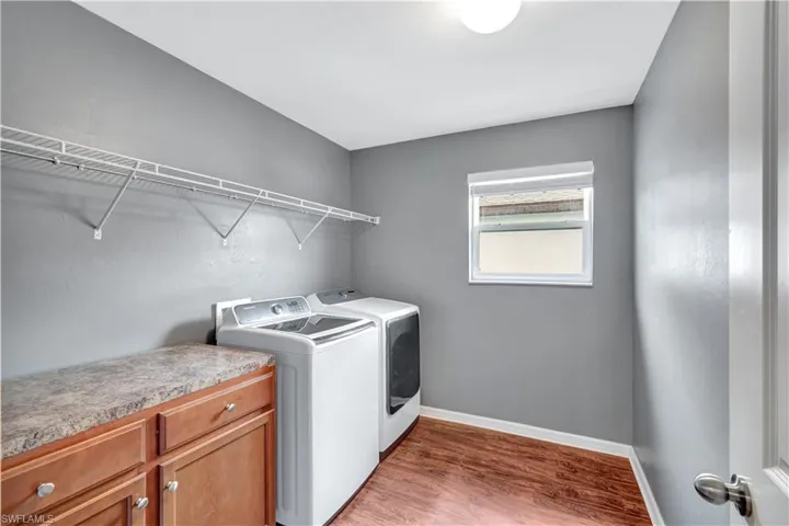 Washroom with dark wood-style floors and separate washer and dryer