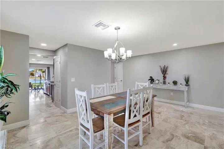 Dining room featuring recessed lighting, a chandelier, and light marble finish flooring