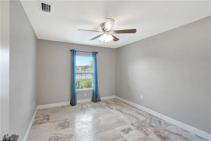 Empty room featuring baseboards and ceiling fan