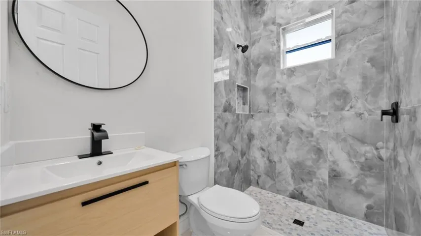 Full bathroom with a marble finish shower and vanity