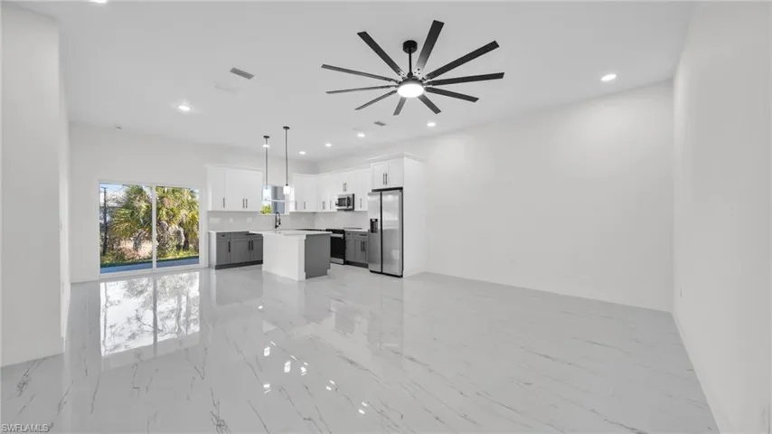 Unfurnished living room with ceiling fan, recessed lighting, and light marble finish floors