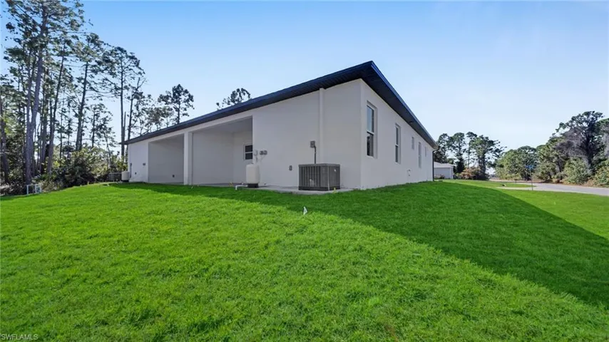 View of side of property featuring a yard and stucco siding